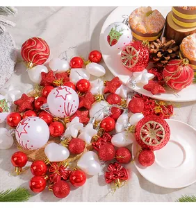 Detailansicht festlicher rot-weißer Weihnachtskugeln und Sterne auf einem hellen Tuch