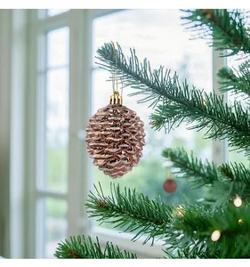 Vue détaillée d'une boule de Noël en forme de pomme de pin rose gold pailletée