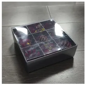 Primer plano de adornos navideños rojos flocados en caja de regalo transparente