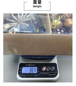 Une balance numérique affiche le poids de 364g d'un set de décorations de Noël ici