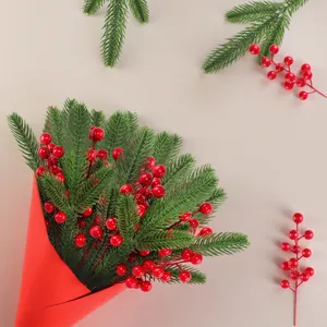 Artificial Christmas pine needles and red berry bouquet for festive home desktop decoration
