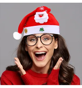 Femme joyeuse portant un bonnet de Père Noël lumineux avec appliqué Père Noël mignon