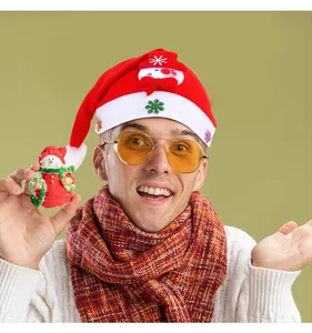 Gros plan d'un homme portant un bonnet de Noël rouge à LED avec décor de bonhomme de neige