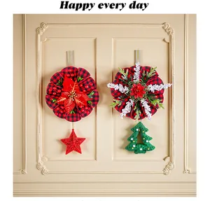 Nahaufnahme von karierten Weihnachtskränzen mit Poinsettia-, Stern- und Baumanhängern