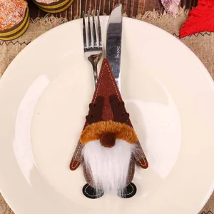 Christmas gnome cutlery holder made of brown felt fabric on a white dinner plate