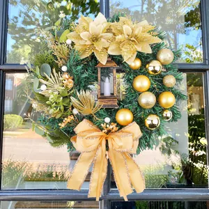 Elegante ghirlanda natalizia con fiori dorati, lanterna e fiocco per decorazione porta