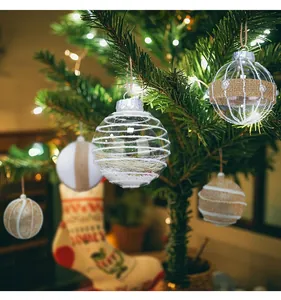 Detailed view of various decorative Christmas baubles hanging on a festive pine tree