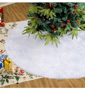 Plush white Christmas tree skirt detail under a decorated pine tree with red berries.