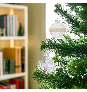 Detail view of clear Christmas ornaments with deer and burlap ribbon hanging on tree