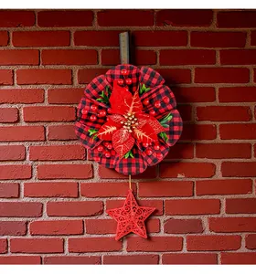 Detailansicht eines Weihnachtskranzes mit rotem Stern vor einer roten Ziegelwand