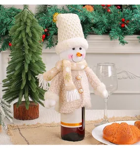 Detail of a cute snowman wine bottle cover with a plush coat and knitted hat.