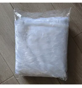 Detail view of white faux fur Christmas tree skirt in clear plastic packaging
