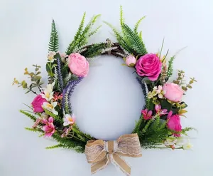 Detailed view of handmade artificial rose wreath with burlap bow and greenery