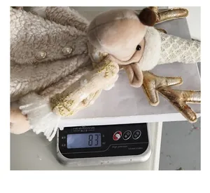 Weight measurement view of plush reindeer wine bottle cover, showing 83 grams on scale.