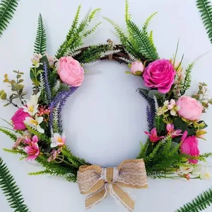 Elegant artificial flower wreath with pink roses and burlap bow for wedding wall decor.