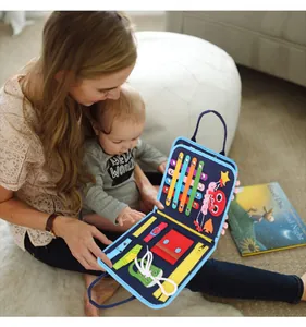 Toddler busy board toy shown in a lifestyle setting with mother and baby