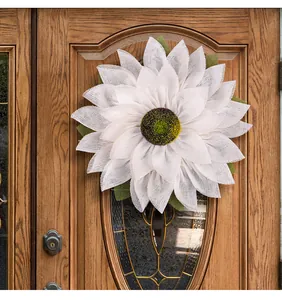 Detailed view of a white burlap sunflower wreath decorated on a rustic wooden door