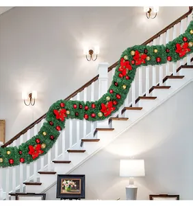 Festive PVC Christmas garland with red poinsettias and ornaments on staircase