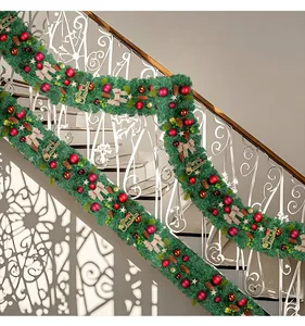 Detailed view of PVC Christmas garland with red balls and pine cones on staircase