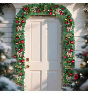 Detailed view of lush PVC Christmas garland with red ornaments and pine cones on a white door