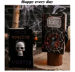 Close-up detail of Halloween resin ghost book models featuring skull and spider motifs