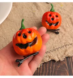 Gros plan détaillé d'une pince à cheveux citrouille souriante avec clip en métal noir.