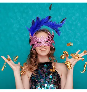 Vue détaillée du masque de fête rose vif avec des plumes bleues pour le carnaval