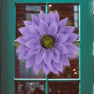 Purple burlap sunflower wreath hanging on a green wooden door for home decoration