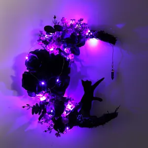 Detailed view of Halloween moon cat wreath with glowing purple LED lights and black roses