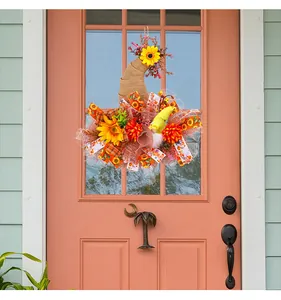 Vue détaillée d'une couronne d'automne avec tournesols et gnome sur une porte rose