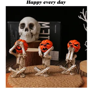 Three pumpkin head skeleton figurines in meditation poses for spooky Halloween home decor.