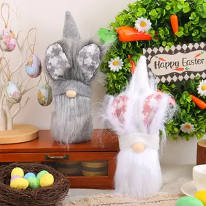 Paire de jolies poupées en peluche nains de Pâques gris et blanc dans un décor festif