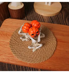 Dettaglio di statuette di scheletri yoga con testa di zucca per decoro di Halloween
