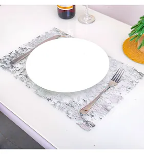 Silver metallic foil mesh placemat on a table with a white plate and cutlery