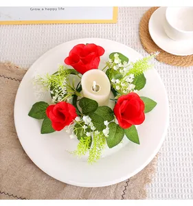 Detailed view of a handmade red rose candle ring wreath on a decorative white plate