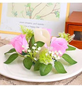 Close-up of pink rose candle ring wreath on a white decorative plate