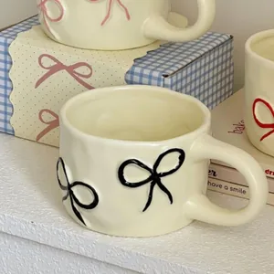 Vista dettagliata di tazza in ceramica con motivo a fiocco nero e texture irregolare.