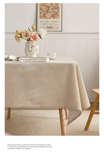 Detailed view of the natural linen texture and draped edge of the beige tablecloth