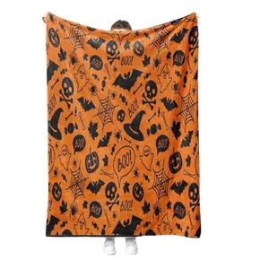 Soft orange Halloween flannel blanket featuring spooky black pumpkin and ghost pattern prints