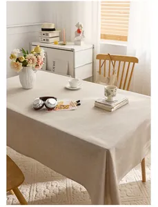 Elegant solid beige linen-style rectangular tablecloth shown in a warm, minimalist room
