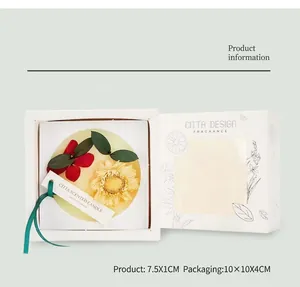 Vue détaillée d'une tablette de cire parfumée aux fleurs séchées dans sa boîte cadeau