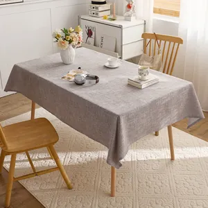 Grey linen-textured rectangular tablecloth on a wooden dining table in a cozy room