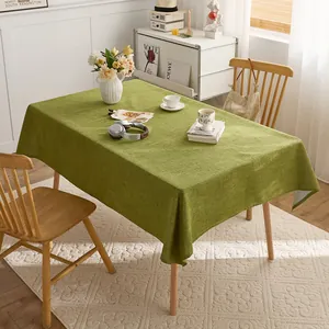 Solid grass green linen style rectangular tablecloth displayed in a cozy home dining scene