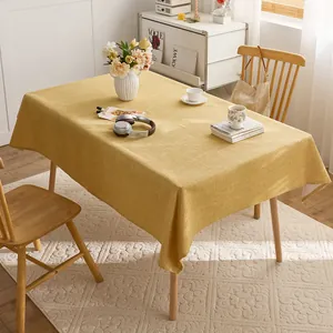 Premium yellow cotton linen tablecloth with textured finish in a warm home setup.