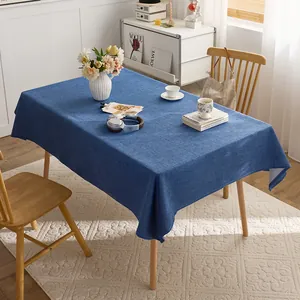 Detailed view of dark blue linen texture tablecloth in a bright modern dining room