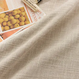 Close-up of beige linen textured tablecloth with natural thick weave pattern for home