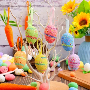 Huevos de Pascua de espuma de colores y colgantes de zanahoria en árbol blanco