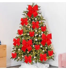 Grandi fiocchi decorativi in velluto rosso vivo appesi a un albero di Natale festivo