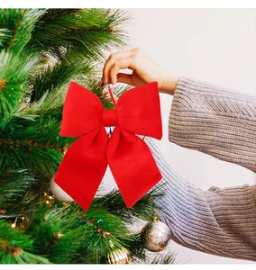 Grande fiocco festivo di velluto rosso appeso a un ramo di albero di Natale decorativo