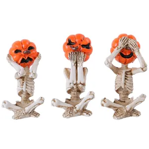 Tre figurine di scheletri di Halloween con teste di zucca in pose di yoga da meditazione.
